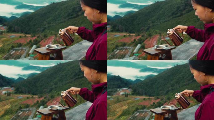 女人咖啡师的手将热水从罐子里倒入阿拉比卡咖啡，在山顶背景的过滤器中。蘸咖啡慢旅行生活方式的概念。4k