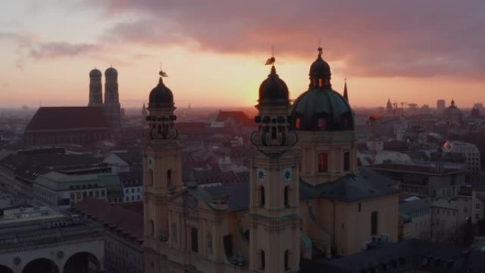 环绕德国城市慕尼黑一座令人惊叹的漂亮大教堂，两座塔在美丽的日落灯光下窥视着古老的建筑，空中滑梯左