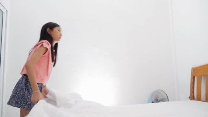 亚洲女孩在家卧室里摇晃白色毯子，慢动作。