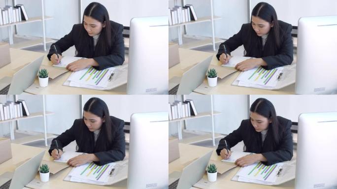 在办公室工作，年轻女子在桌子上写作