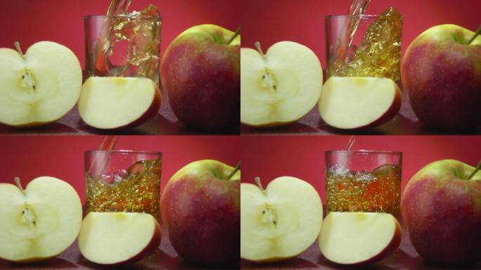 将新鲜的苹果汁倒入慢动作的红色背景上的玻璃杯中