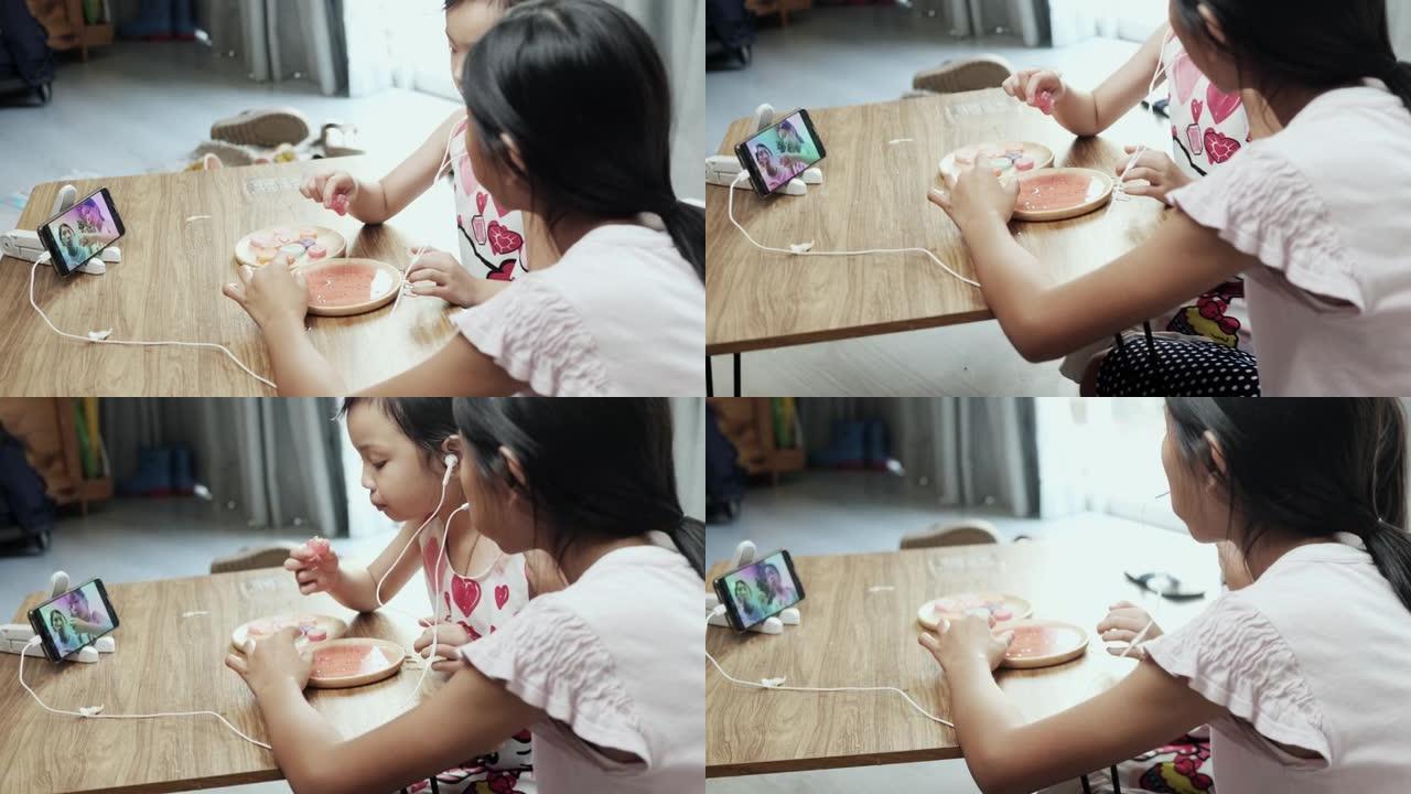快乐的亚洲儿童在家一起制作ASMR零食咬音的YouTube内容，周末活动概念。