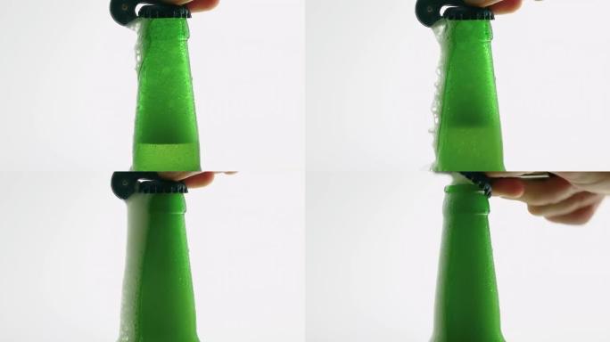 一个男人用开瓶器打开一瓶啤酒，泡沫啤酒从瓶子里倒出来，啤酒装在白色背景上的瓶子里。