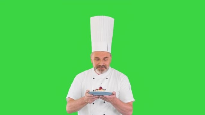 快乐成熟的厨师在绿色屏幕上与沙漠同行，色度键