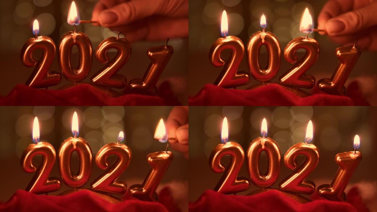 手灯2021年形式的金色蜡烛。节日圣诞节背景上的金色燃烧蜡烛。新2021年快乐庆典