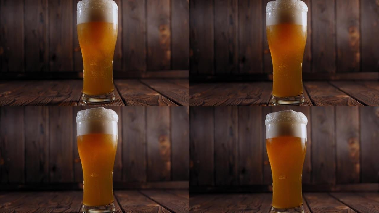 调酒师将清淡的新鲜冰镇啤酒倒入木制背景上的玻璃杯中。