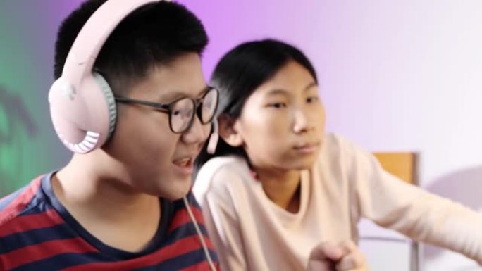 快乐的亚洲儿童在晚上在家玩网络游戏，带led灯背景，生活方式理念。