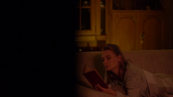 女人躺在客厅沙发上看书