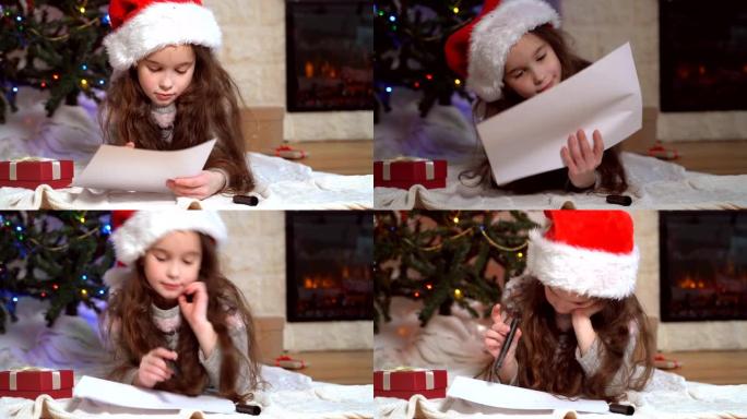 戴着圣诞老人帽子的微笑女孩写信给圣诞老人。圣诞奇迹愿望清单。孩子躺在带圣诞灯的圣诞树前装饰好的家里。