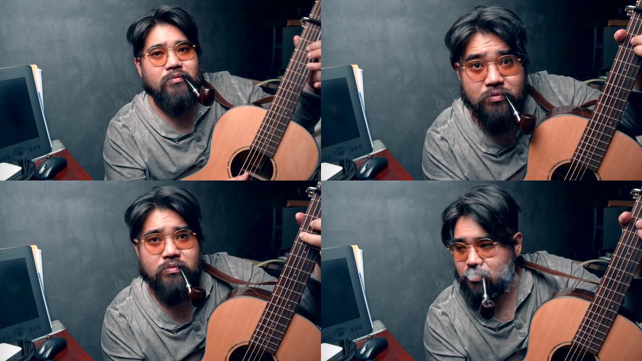 亚洲小胡子男人在家里努力工作时弹吉他放松