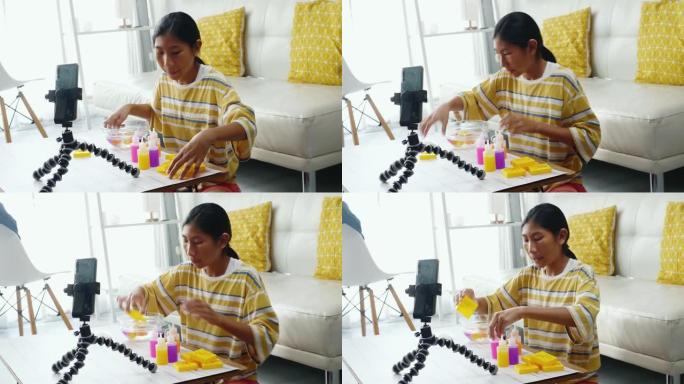 快乐的亚洲女孩在家中通过智能手机玩玩具和vlog视频作为YouTuber，现代生活方式概念。