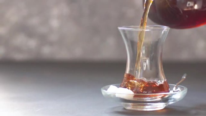 从茶壶中倒出的土耳其红茶，传统的热饮，慢动作