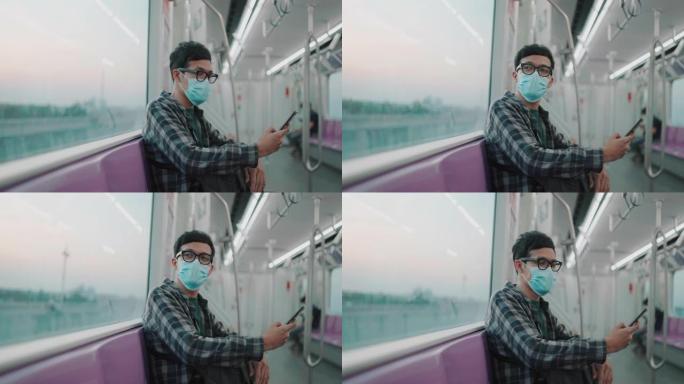 一名男子使用智能手机并在火车上眺望风景