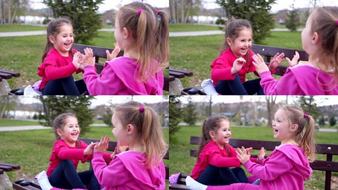 可爱无辜的兄弟姐妹在公园长椅上玩得开心