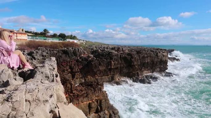 在晴朗的天气里，强大的海浪撞击岩石。纯粹的力量，自然力量的展示。强能量。对抗地球的海洋力量。年轻的金