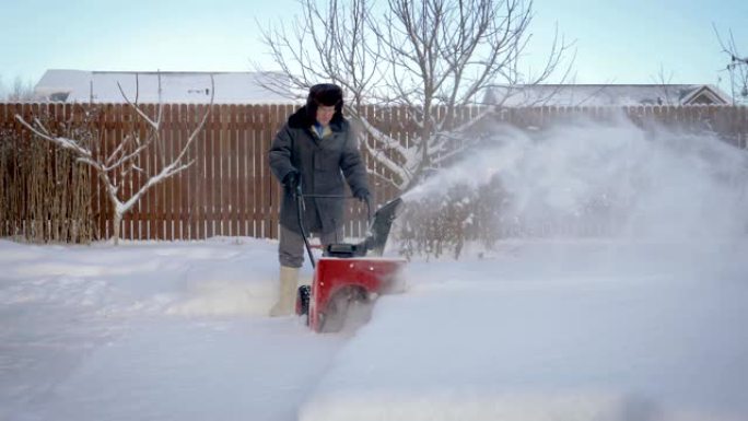 男子在家除雪机降雪后清理积雪