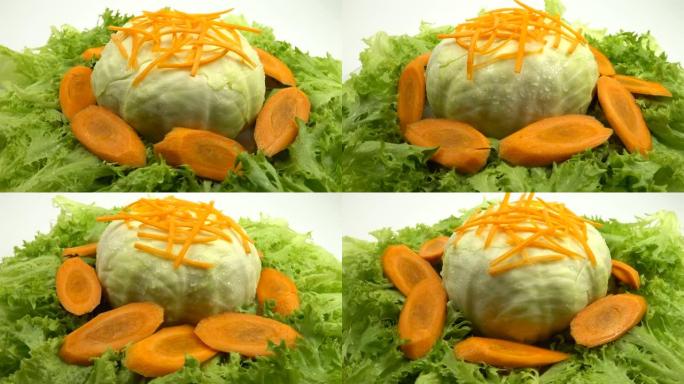 整个白菜和一片胡萝卜躺在莴苣叶上