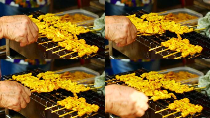 食品视频沙爹猪肉或鸡肉用竹子制成，然后在柴炉或木炭烤箱上烧烤，街头食品沙爹的调味料来自印度尼西亚的爪