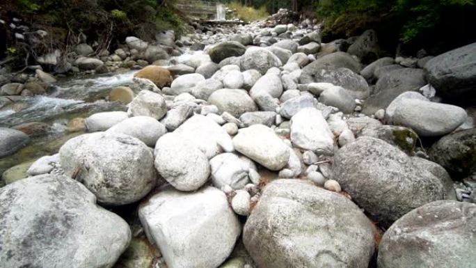 清澈的山河溪流，小瀑布和弯曲的圆形石岩，电影摄影机拍摄，慢动作