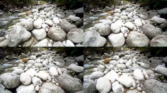 清澈的山河溪流，小瀑布和弯曲的圆形石岩，电影摄影机拍摄，慢动作