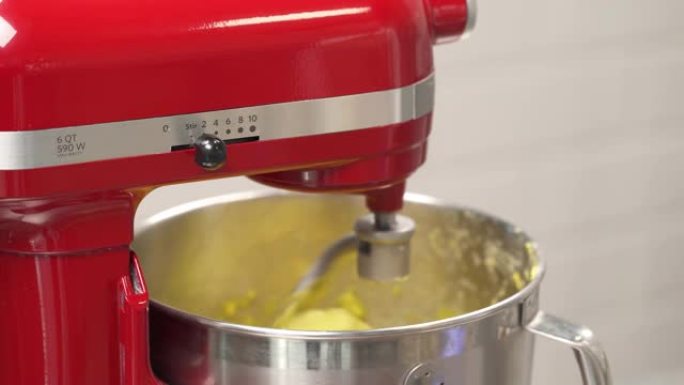 专业捏合机螺旋机混合面团的特写镜头，用于面包烘烤。厨师改变混合速度。食物制备概念。混合配料