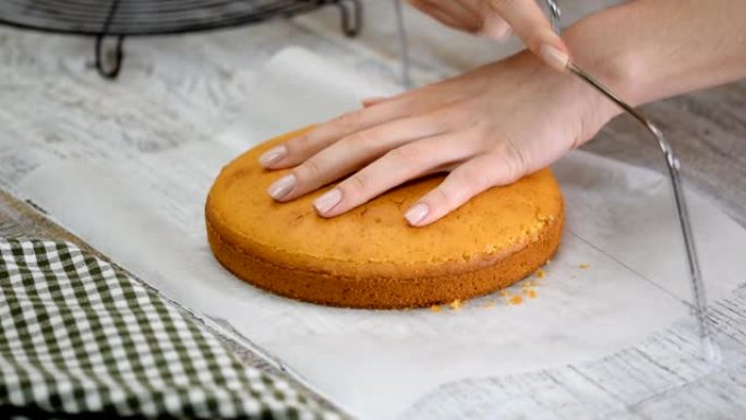 糕点厨师将海绵蛋糕切成层。蛋糕生产流程