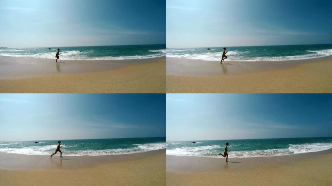 男孩在沙滩上奔跑，当波浪推动他时摔倒