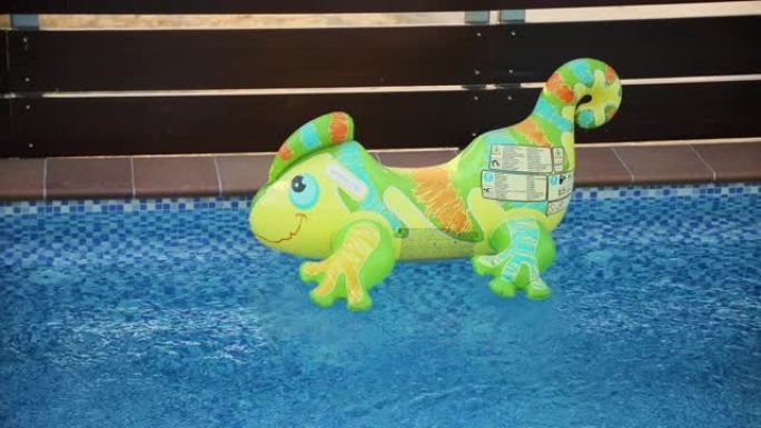 漂浮在豪华别墅后院空水池中的充气蜥蜴玩具