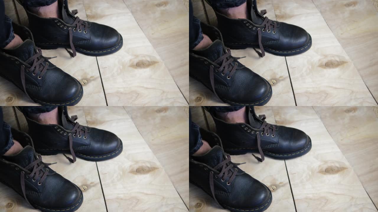 工作皮靴随着音乐跳舞。跺脚。节奏。动。特写博克变焦。棕色鞋子。由木头制成的胶合板地板会在重量下弯曲。