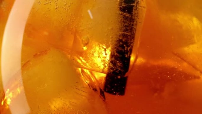 橙色Spritz鸡尾酒的特写镜头，冰块与黑色吸管慢动作一起饮用