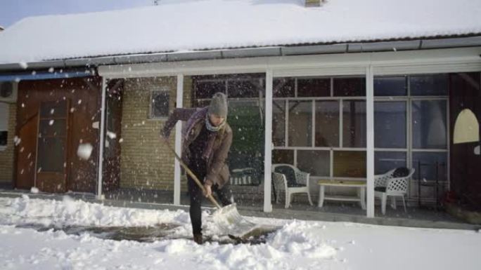 男子在院子里铲雪