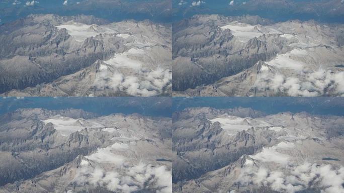 夏季飞越阿达梅洛普雷萨尼拉阿尔卑斯山。冰川景观。飞机窗口的鸟瞰图