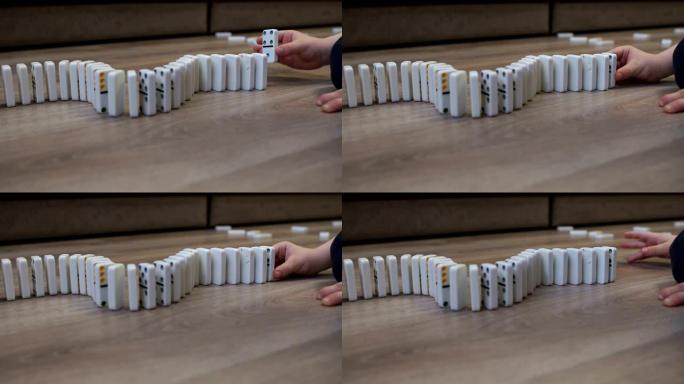 一个孩子在家玩多米诺骨牌的特写镜头。