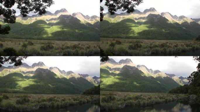 新西兰阳光下的绿色山脉全景。