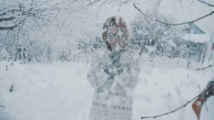 那个戴着眼镜，穿着毛衣和连指手套的女孩在冬天的降雪下站在街上。慢动作。