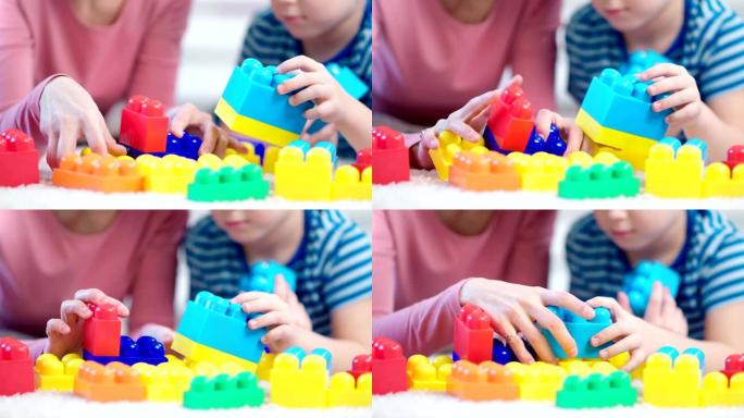 测试过程中，女性儿童心理学家和小男孩玩彩色立方体的特写手