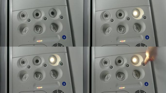 飞机上的乘客打开灯。特写。手动按下飞机上的个人照明按钮。