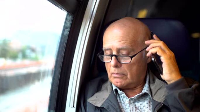 老秃头男子在移动火车内用手机聊天-模型发布