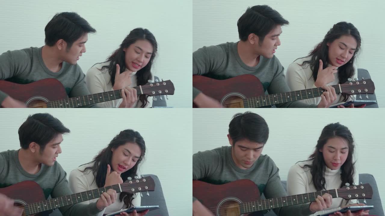 亚洲年轻夫妇一起弹吉他唱歌