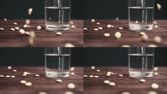 药丸散落在一杯水周围。
