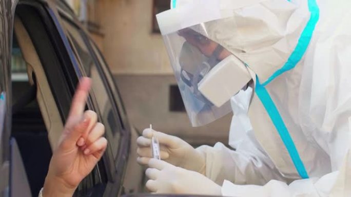 女人拒绝PPE的医务人员试图进行直通车新型冠状病毒肺炎测试