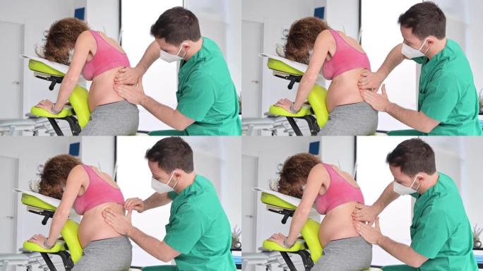 男性理疗师可以治愈孕妇的背痛。高质量4k镜头。