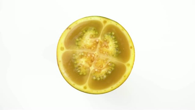 从上方的naranjilla水果切成两半，在转盘上旋转，在白色背景上隔离。