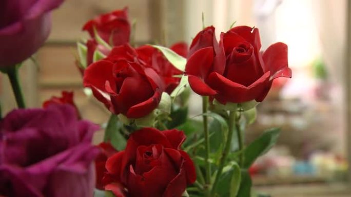 农贸市场花店入口处的一束五颜六色的玫瑰和其他鲜花。日常花卉柜台有各种鲜切花。许多美丽的鲜花花束。