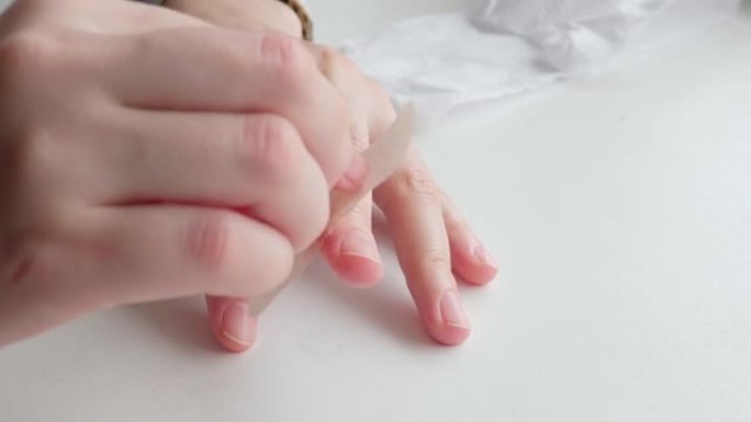 手在手指上的伤口上贴了一块创可贴。
