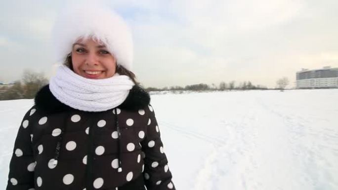 女孩走过冬天的荒原。微笑和手势。周围有很多雪。