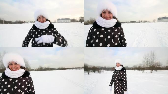 女孩走过冬天的荒原。微笑和手势。周围有很多雪。