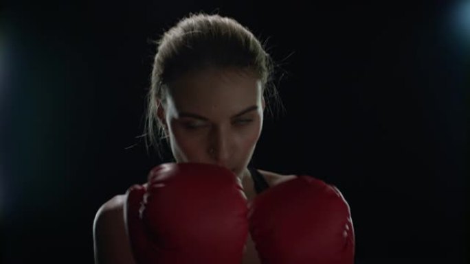 运动女子在有氧训练中戴着红色拳击手套拳打。女拳击手