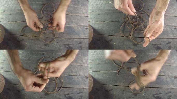 皮绳花边用手缠绕。自制。木质背景皮革制作，配有男士双手。4k，30 fps。