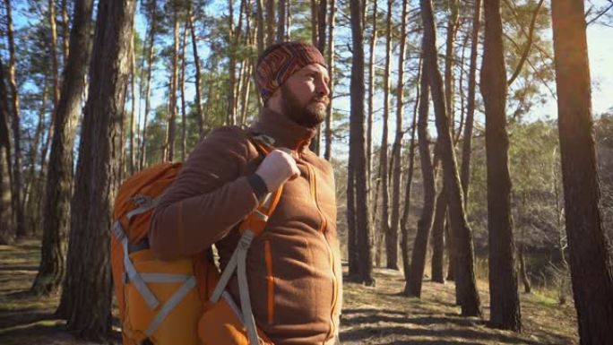 在旅行和冒险中准时。带背包的大胡子旅行者的腰部肖像使用技术运动手表在森林中导航gps电子罗盘并看着他